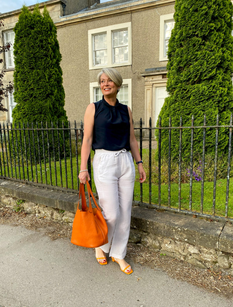 Midlifechic white linen trousers with navy sleeveless blouse