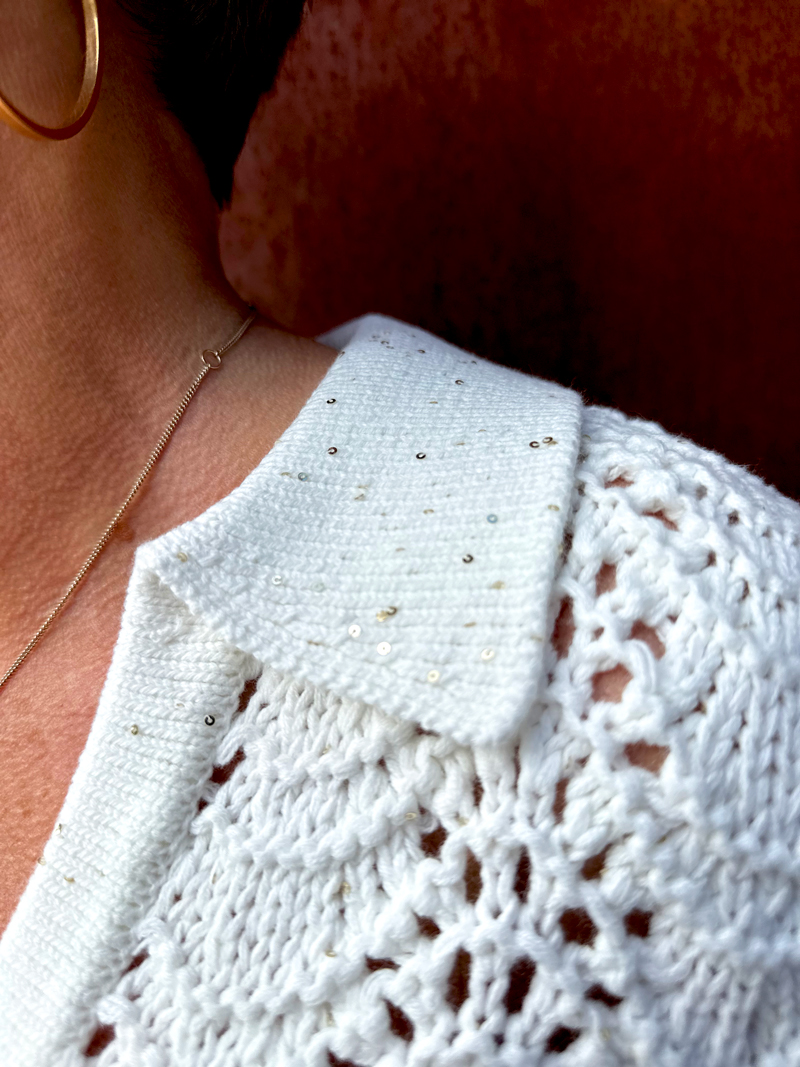 Close-up detail of the crochet top showing tiny gold sequins scattered through the weave